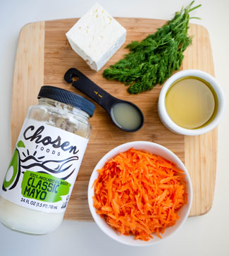 Ingredients for Creamy Shredded Carrot Salad displayed on a cutting board