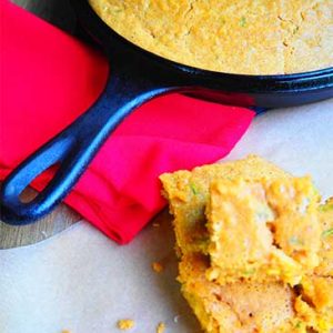 Cornbread in cast iron skillet with butter on top