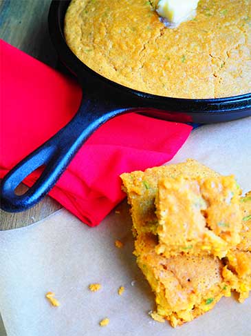 Cornbread in cast iron skillet with butter on top