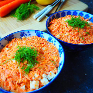 Creamy Shredded Carrot Salad in two bowls garnished with feta cheese and dill