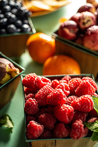 A bowl of raspberries and other healthy fruits on a table