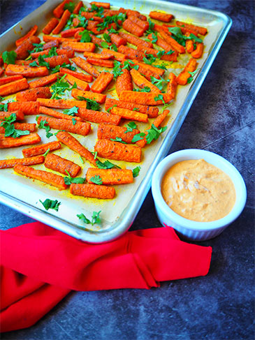 Roasted Carrots with Turmeric alongside dipping sauce