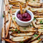 Homemade Pommes Frites on a baking sheet with ketchup