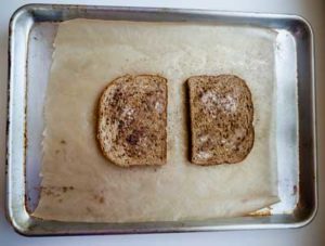 Buttered bread with cinnamon on a baking sheet
